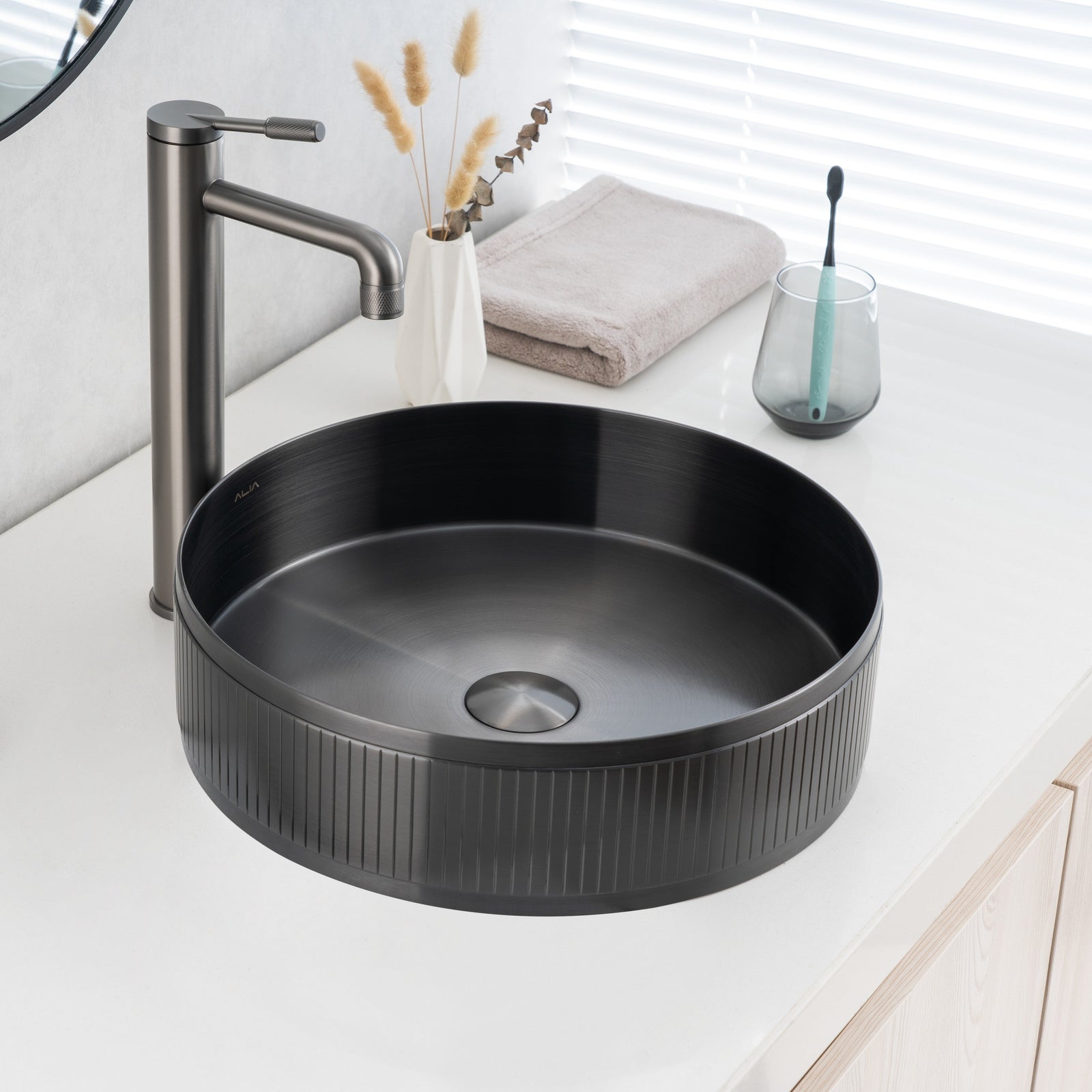 Real image of ALIA textured gunmetal grey round basin installed on a vanity, showcasing its matte surface and detailed texture.