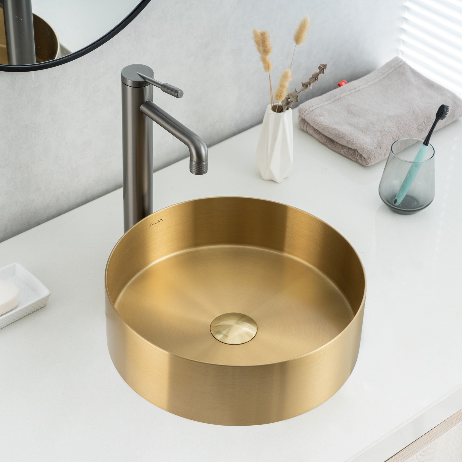Close-up of installed ALIA brushed gold bathroom sink showcasing its reflective surface, smooth curves, and luxurious modern appeal.