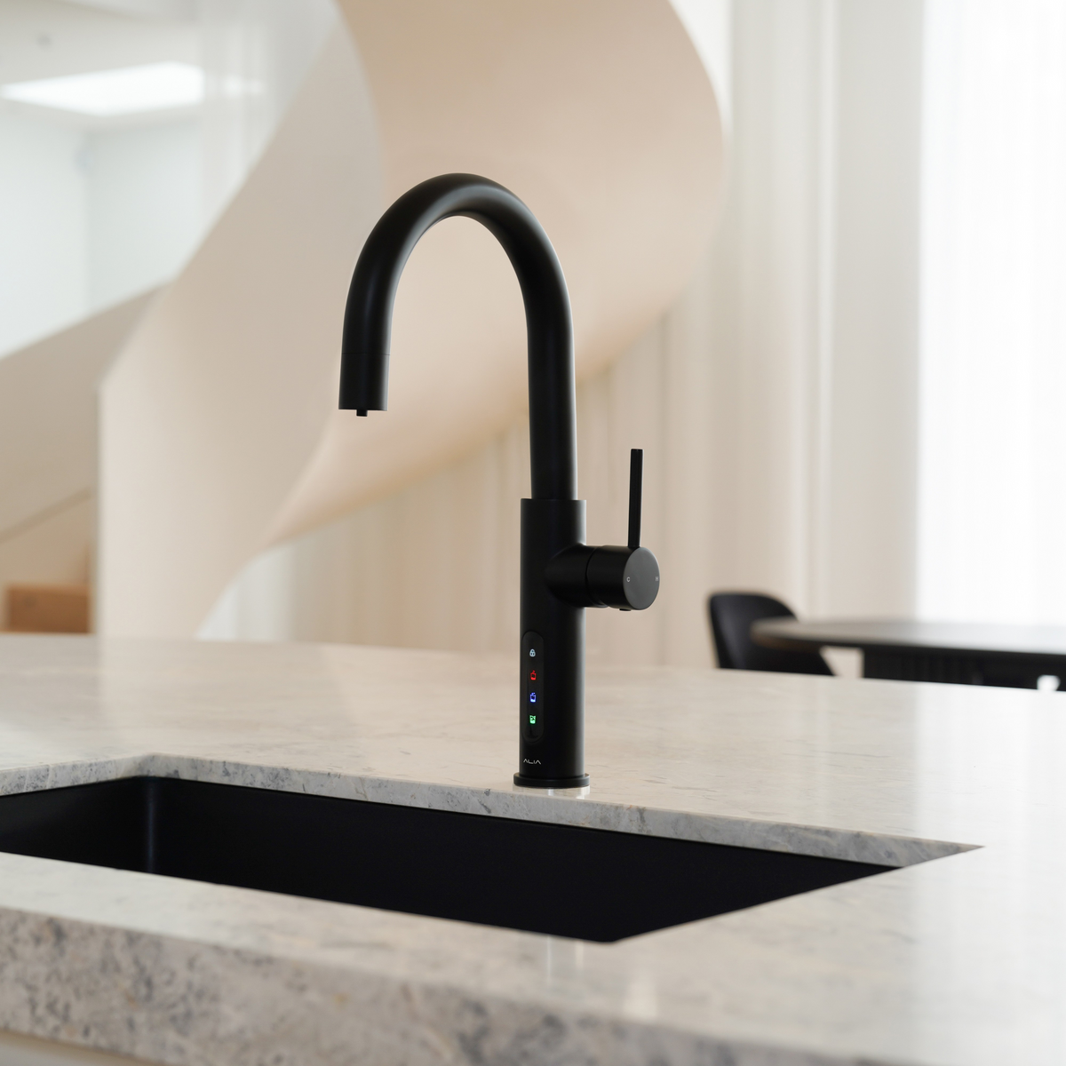 Alia X51 instant hot, cold, and sparkling filtered water tap in matte black accenting a luxury kitchen, highlighting its premium filtered water and bold contemporary design.