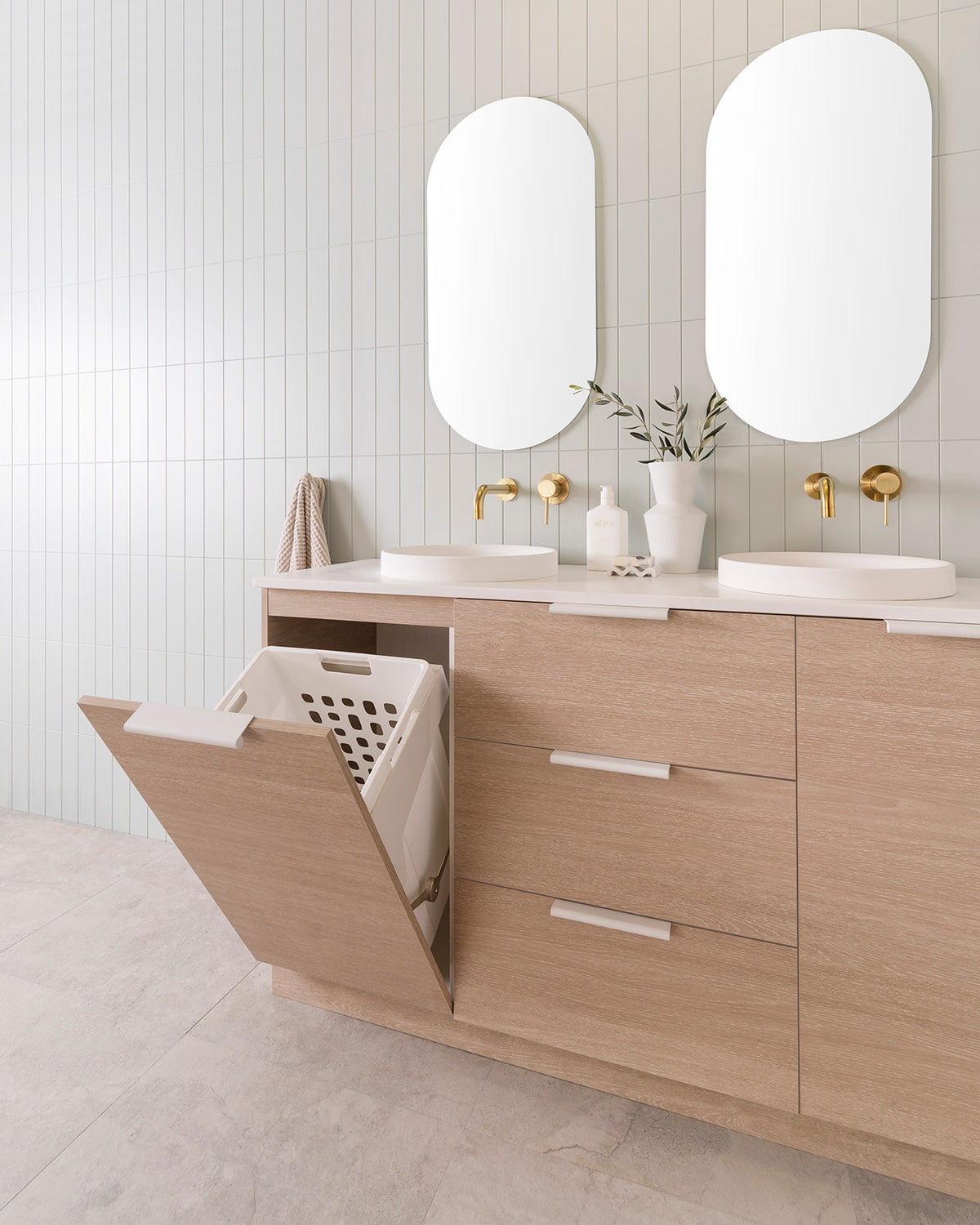 Glacier Hamper vanity, 1500 Double Bowl. Coastal Oak Woodmatt cabinet finish with Matte White Francis handles 20mm Frost Cherry Pie benchtop with Matte White Respect Semi-Inset basins. 2 x 450mm Pill Polished Edges Mirrors.
