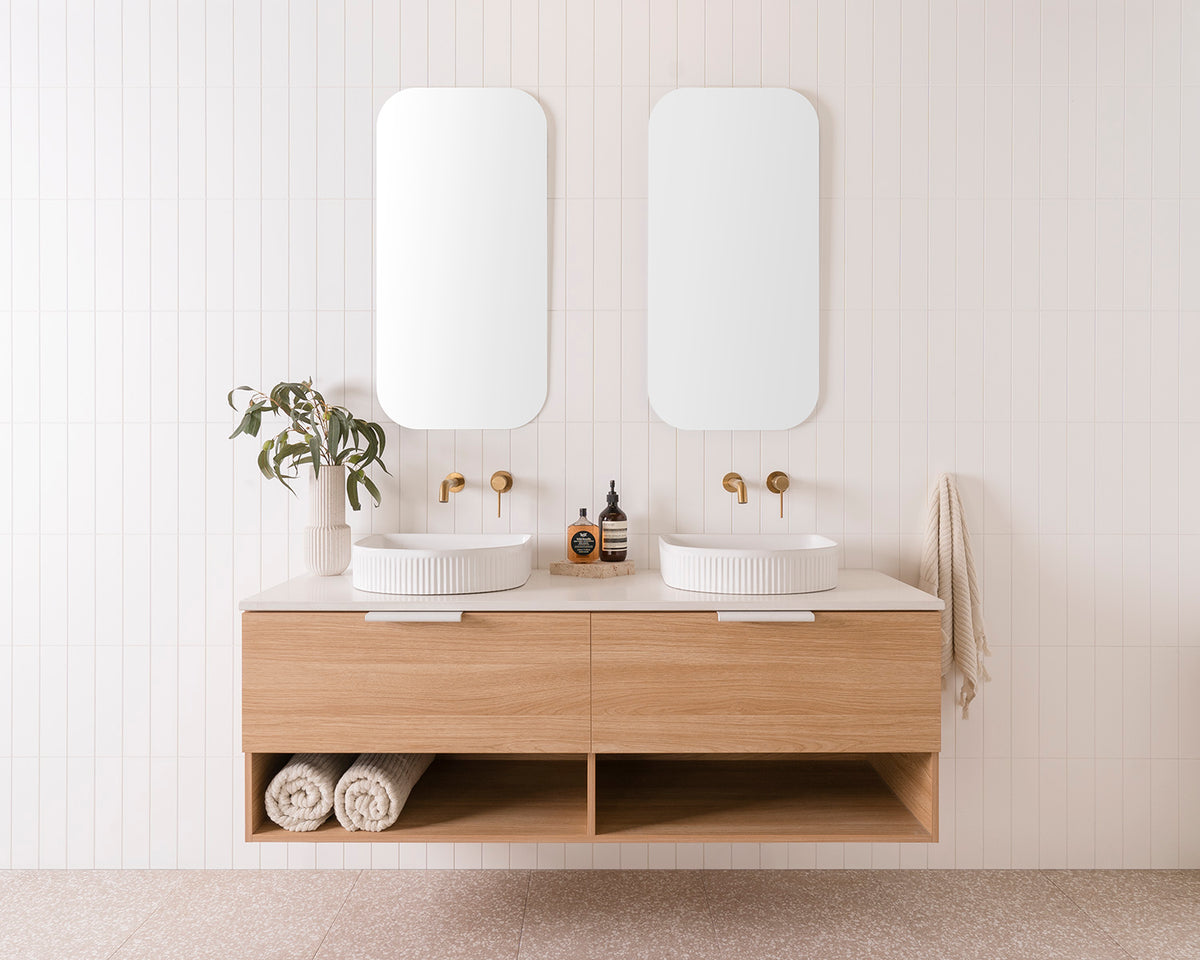 Glacier Pro Full depth, Shelf, Slim 1500 Double Bowl. Elegant Oak Woodmatt cabinet finish with Matte White Francis Handles. 20mm Organic White Caesarstone Benchtop and Arch Fluted Basins. 2 x 450mm Stadium Mirrors